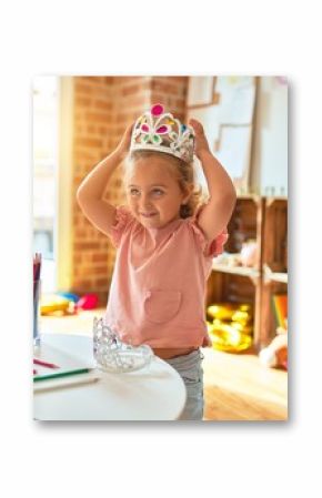 Beautiful blond toddler girl wearing princess crown standing at kindergarten
