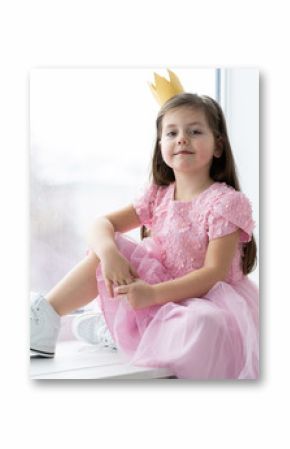 Cute little girl in a princess costume. Pretty child preparing for a costume party. Beautiful queen in gold crown.