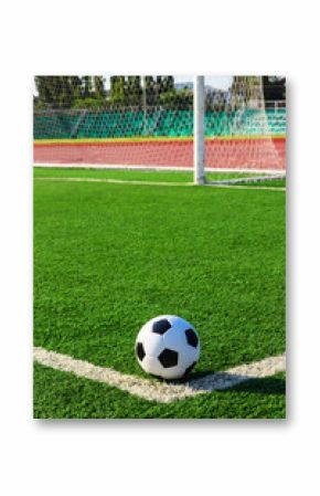 soccer ball on green grass in front of goal net