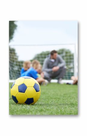 Coach  And Team Discussing Soccer Tactics With Ball In Foregroun