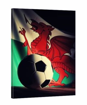 Flag of Wales with football on wooden boards as the background. Vintage style.
