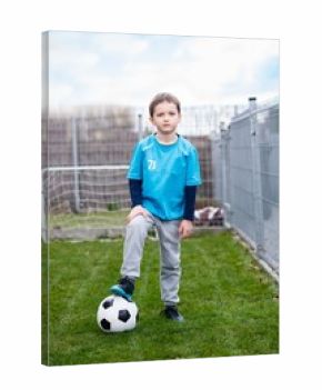 7 years boy - footballer with his feet on football ball