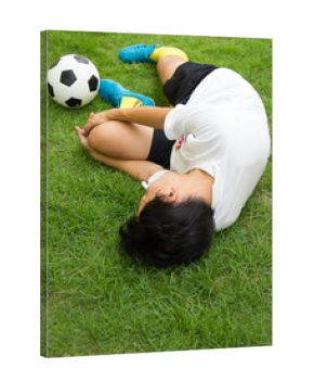 Football player lying injured on the pitch.