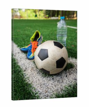 Football cleat and fresh water after the match on the field