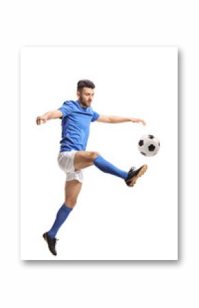 Soccer player jumping and kicking a football