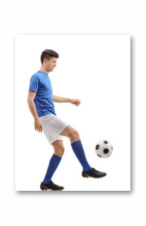 Teenage soccer player juggling a football