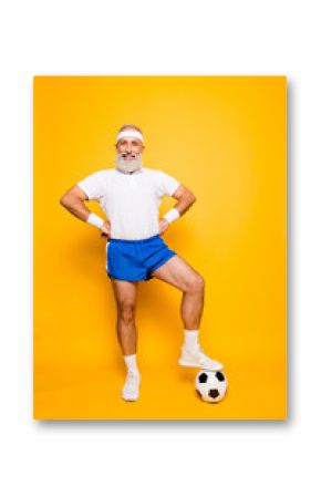 Full length of modern cool funny competetive pensioner, leader, champion with his foot on a ball. Bodycare, healthcare, weight loss, pride, strength, leadership, motivation, authority, gym