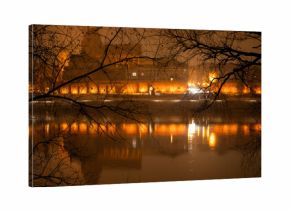 Toruń nocą, stare miasto nad rzeką Wisłą, światła odbijające się w wodzie. 