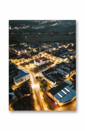 Miasto nocą z powietrza, oświetlone ulice i budynki   