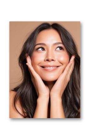 Beautiful Woman with Hands on Face Looking Upward Smiling with Long Brown Hair in Studio Shot