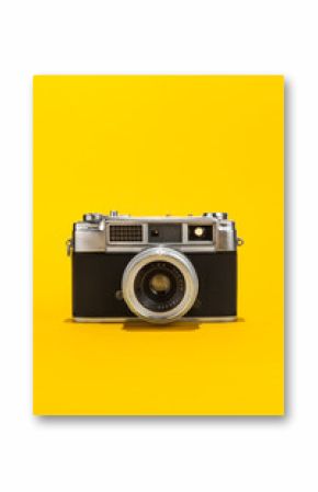 Retro analog film camera on yellow background