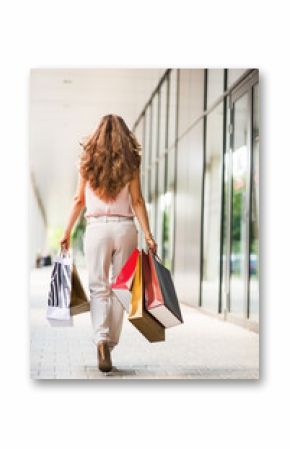 Young woman with shopping bags walking on the mall alley