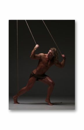 Young naked man, muscular body, bounded with rope