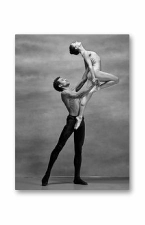 Couple of ballet dancers posing over gray background