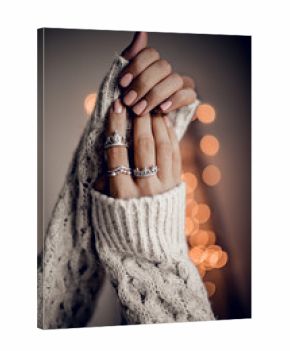 Hands with silver rings on golden bokeh lights background