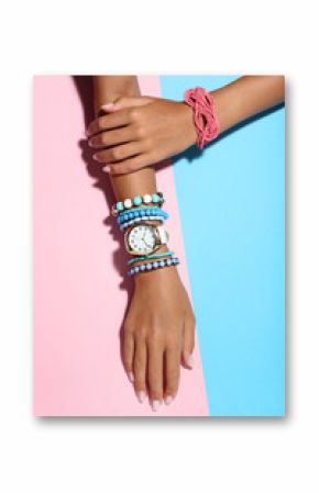 Female hands with bracelets on colorful background