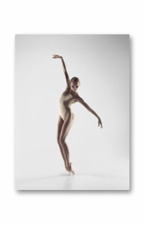 Young graceful female ballet dancer or classic ballerina dancing on white studio. Caucasian model on pointe shoes