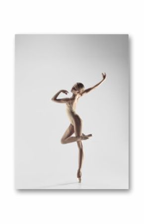 Young graceful female ballet dancer or classic ballerina dancing on white studio. Caucasian model on pointe shoes