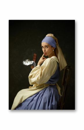 Medieval woman in historical costume wearing corset dress and bonnet. Beautiful peasant girl wearing thrush costume with sweet chocolate bar over dark studio