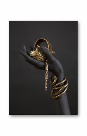 Black woman's hand with gold jewelry. Oriental Bracelets on a black painted hand.