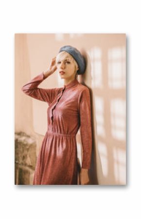 Outdoor portrait of young beautiful fashionable woman wearing stylish pink dress, light blue beret, posing in street. Female spring fashion concept   