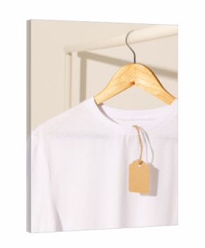 White t shirt with tag hanging from clothes rack with copy space on white background