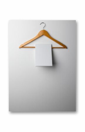 A wooden hanger holds a blank white sheet against a wall with copy space