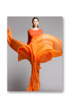 beautiful woman in long orange dress posing in the studio