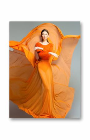 beautiful woman in long orange dress posing in the studio