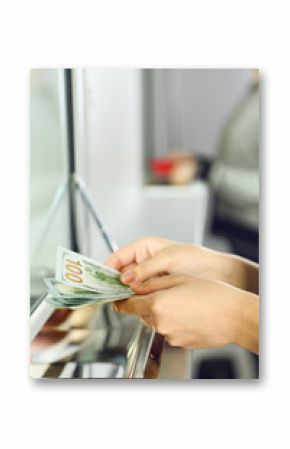 Female hand with money in cash department window. Currency