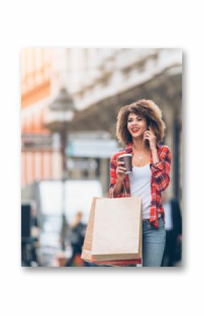 Young woman at the street with shopping bags talking on mobile phone  