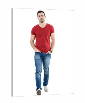 Cool relaxed casual guy with hands in pockets walking and looking at camera. Full body length portrait isolated over white studio background.