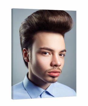 Portrait of young man with retro classic pompadour hairstyle. studio shot. looking at camera.