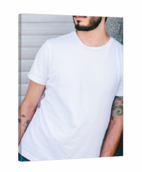 Young man wearing white blank t-shirt, standing on the street. Street photo. No face