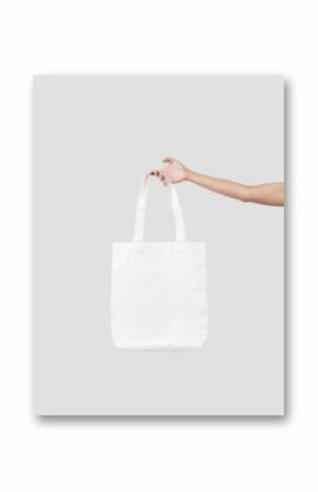 hand holding bag canvas fabric for mockup blank template isolated on gray background.