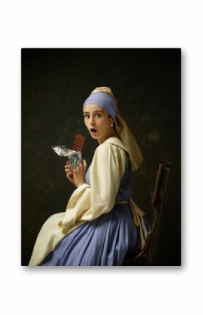 Medieval woman in historical costume wearing corset dress and bonnet. Beautiful peasant girl wearing thrush costume with sweet chocolate bar over dark studio