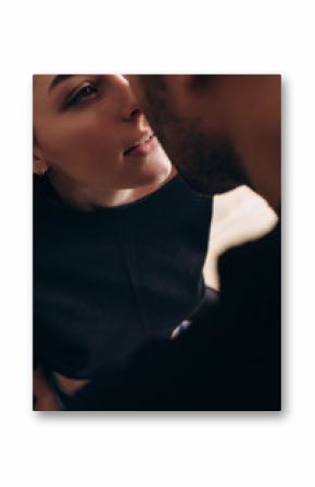 Close-up of young romantic couple is kissing and enjoying the company of each other at home.