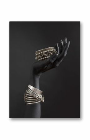 Black woman's hand with Silver jewelry. Oriental Bracelets on a black painted hand. Silver Jewelry