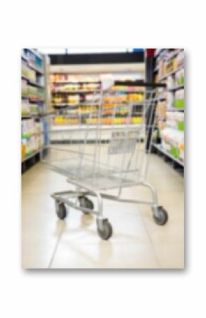 Shopping cart on aisle amidst products on shelves in supermarket