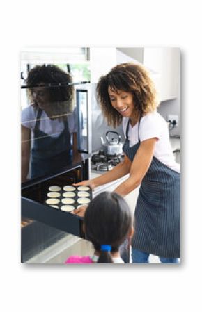 Biracial mother bakes with a biracial daughter at home for her daughter