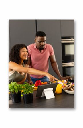 Young biracial African American couple are cooking together in a modern kitchen at home