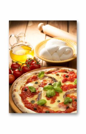 pizza with ingredients on wooden table