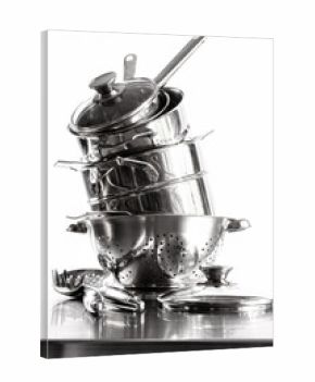 Stack with stainless steel pots and pans on white