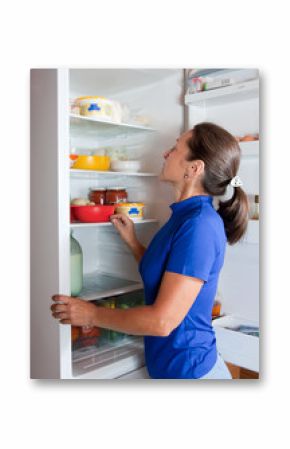 woman at home looking inside the fridge