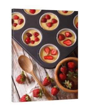 Preparation of muffins with fresh strawberries vertical top view  