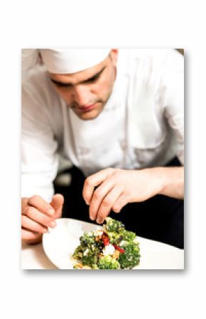 Cook decorating a broccoli salad