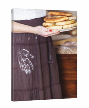 woman is holding plate of cakes, flour skirt handprint