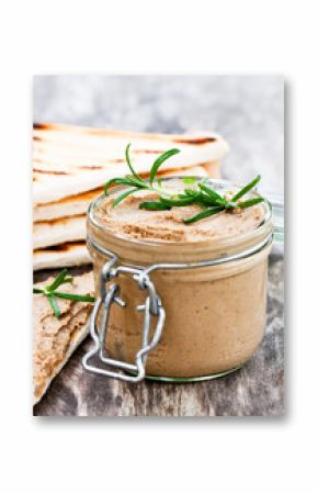 homemadeliver  pate with rosemary in a jar on a rustic wooden ta