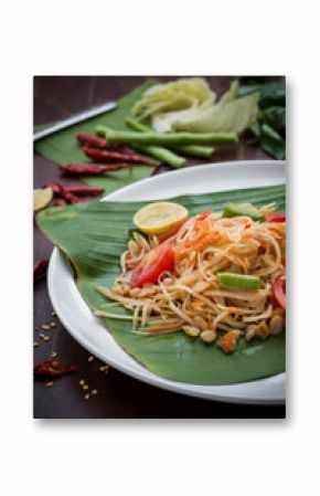Green Papaya Salad (Som tum Thai) on wood table. Green Papaya Salad (Som tum Thai) on wood table. Green papaya salad spicy thai food on banana leaf.  close up of   Som tum Thai menu Asian food.