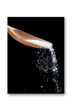Salt shaker,Sea salt on wooden spoon on black background